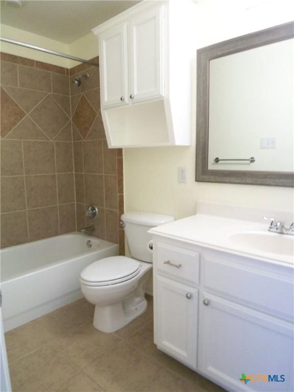 full bathroom featuring tile patterned flooring, tiled shower / bath combo, toilet, and vanity