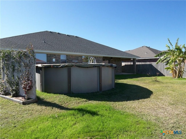 back of property with a lawn and a fenced in pool