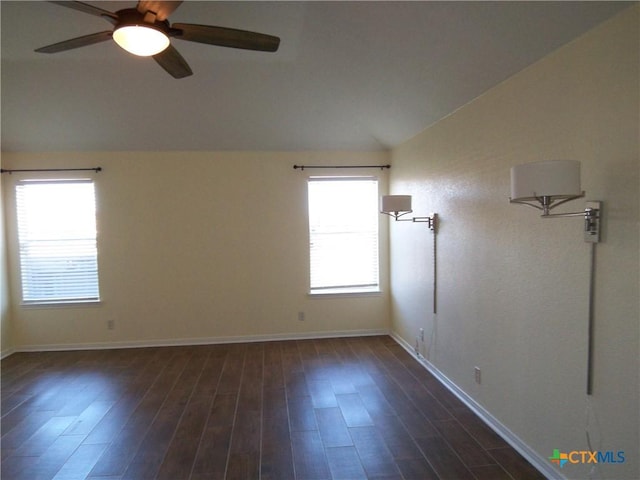 empty room featuring dark hardwood / wood-style flooring, a wealth of natural light, lofted ceiling, and ceiling fan