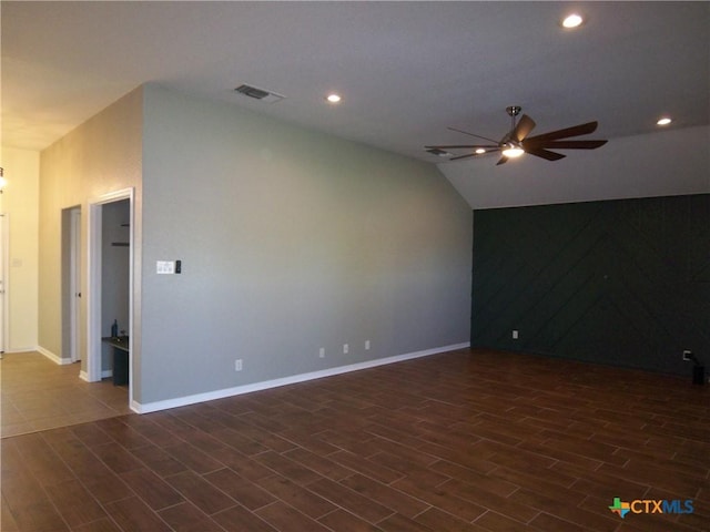 spare room with ceiling fan, dark wood-type flooring, and vaulted ceiling