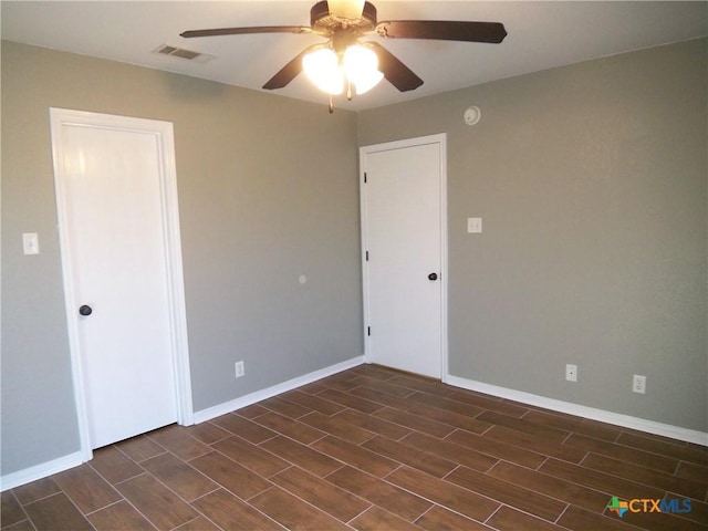 spare room with ceiling fan and dark hardwood / wood-style floors