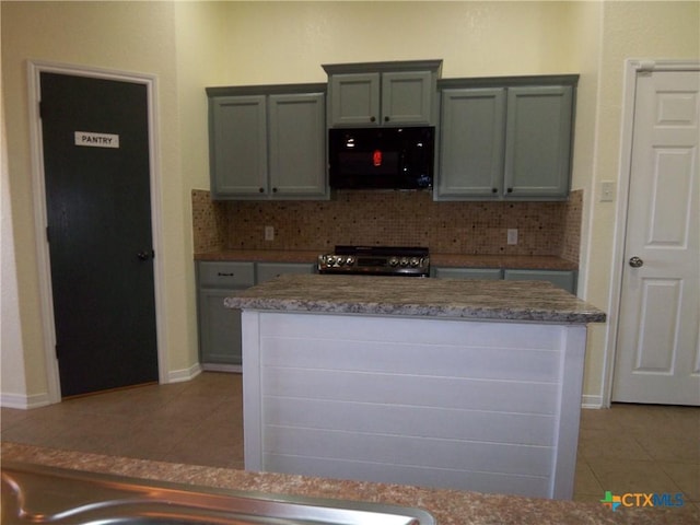 kitchen featuring stainless steel range oven, light tile patterned floors, and tasteful backsplash