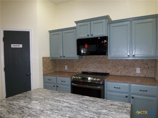 kitchen with decorative backsplash, light stone countertops, and stainless steel electric range oven