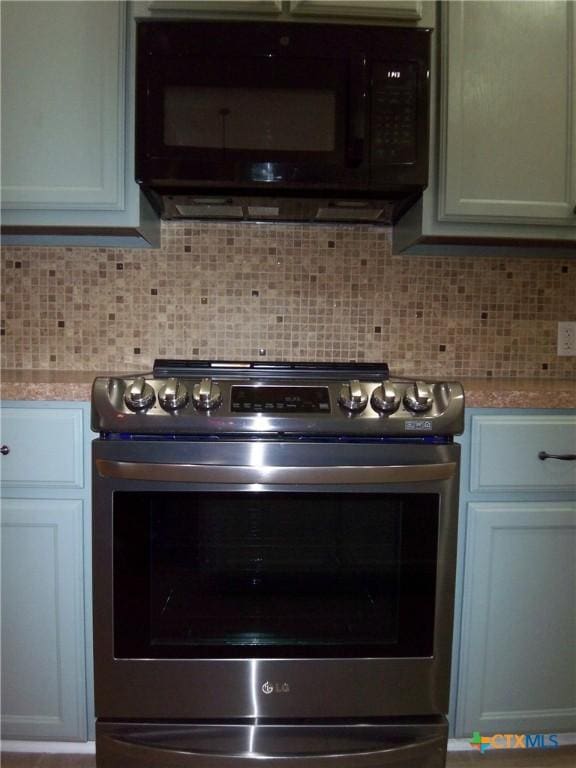 kitchen with stainless steel range with electric stovetop, light stone counters, and backsplash