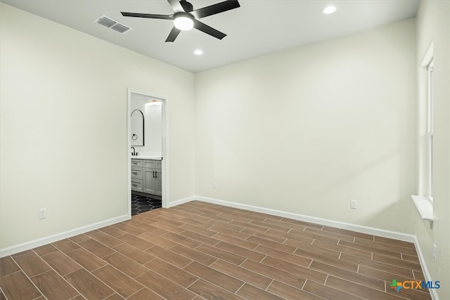 unfurnished bedroom with ceiling fan, dark hardwood / wood-style floors, and connected bathroom