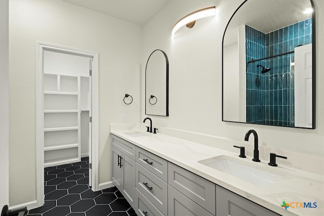 bathroom featuring vanity, tile patterned floors, and tiled shower