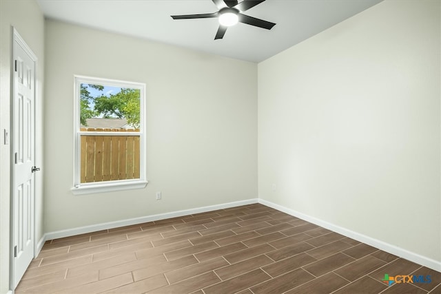 spare room with dark wood-type flooring and ceiling fan