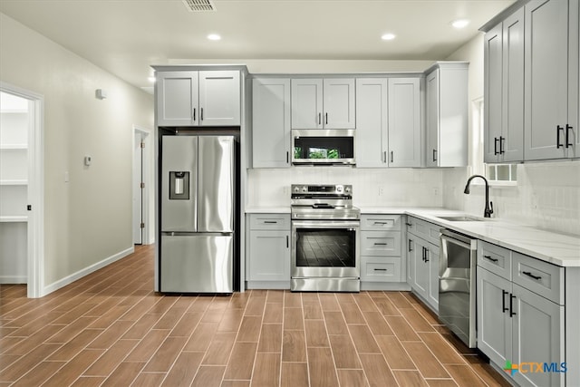 kitchen featuring dark hardwood / wood-style floors, gray cabinetry, sink, and appliances with stainless steel finishes