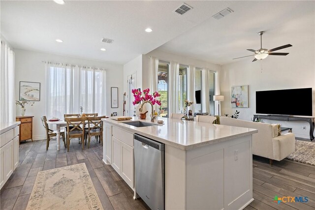 kitchen featuring white cabinets, a kitchen island with sink, a healthy amount of sunlight, sink, and dishwasher