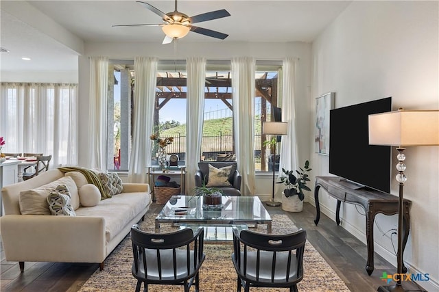 living room featuring ceiling fan and dark hardwood / wood-style floors