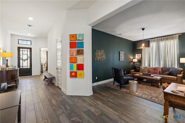 living room featuring dark hardwood / wood-style flooring and a textured ceiling