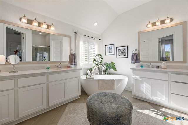 bathroom with hardwood / wood-style flooring, vanity, lofted ceiling, and plus walk in shower