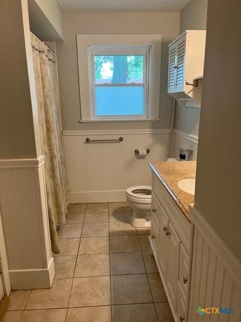 716 Josephine St, Yoakum, TX 77995 - bathroom with a wainscoted wall, tile patterned floors, vanity, and curtained shower