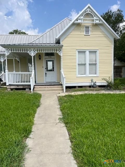 716 Josephine St, Yoakum, TX 77995 - view of front of property with a front yard, a porch, and a metal roof