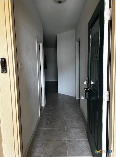 hall with dark tile patterned flooring