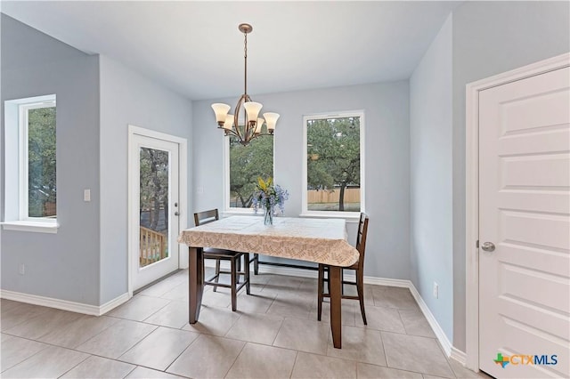 dining space featuring an inviting chandelier, light tile patterned floors, and baseboards