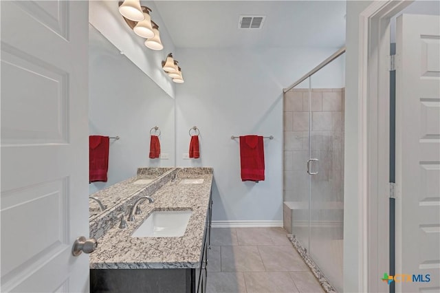 bathroom featuring double vanity, a stall shower, visible vents, tile patterned flooring, and a sink