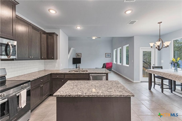 kitchen featuring backsplash, appliances with stainless steel finishes, light tile patterned flooring, a sink, and dark brown cabinetry