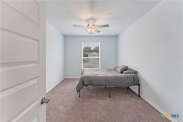 bedroom with a ceiling fan, light carpet, and baseboards