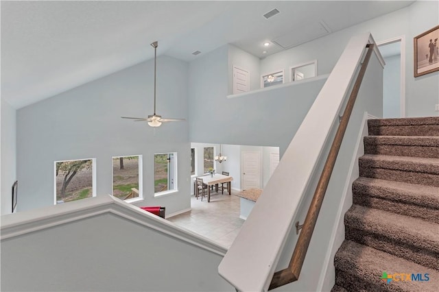 stairway with high vaulted ceiling, visible vents, and a ceiling fan