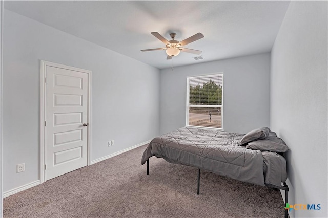 carpeted bedroom featuring ceiling fan, visible vents, and baseboards