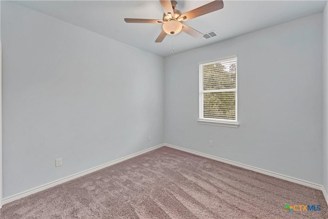 unfurnished room with carpet, visible vents, ceiling fan, and baseboards