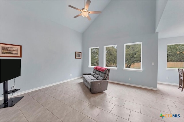 sitting room featuring a ceiling fan, a wealth of natural light, tile patterned flooring, and baseboards