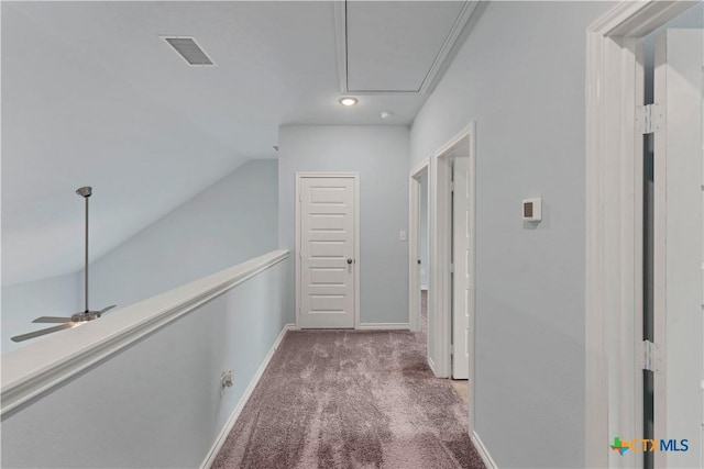 hallway with lofted ceiling, carpet floors, visible vents, baseboards, and attic access