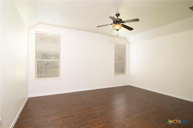 unfurnished room with visible vents, baseboards, dark wood-style floors, ceiling fan, and vaulted ceiling