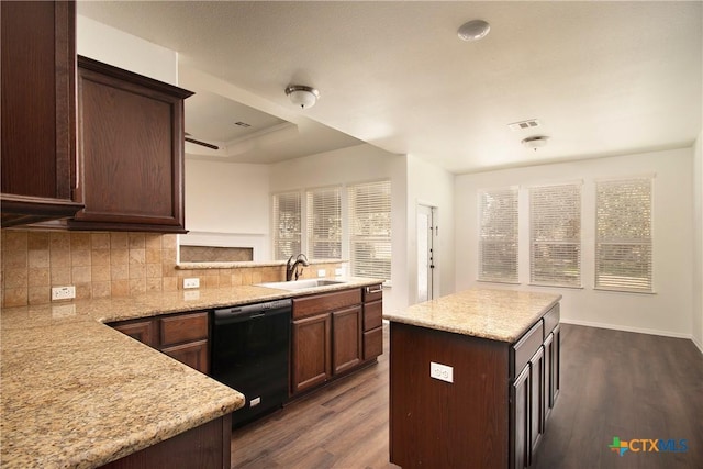 kitchen with a peninsula, dark wood-style flooring, a sink, decorative backsplash, and dishwasher