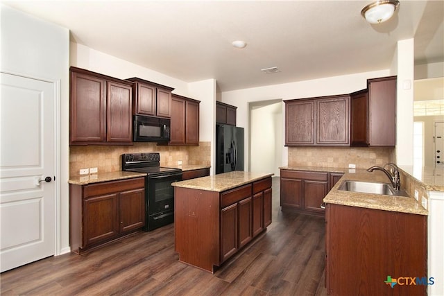 kitchen featuring light stone counters, dark wood finished floors, a sink, and black appliances