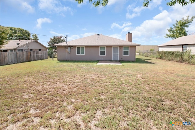 back of house featuring a patio and a yard