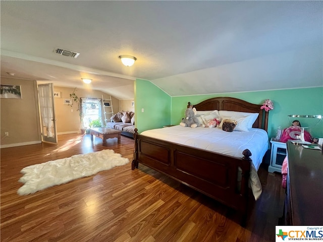 bedroom with lofted ceiling and dark hardwood / wood-style floors