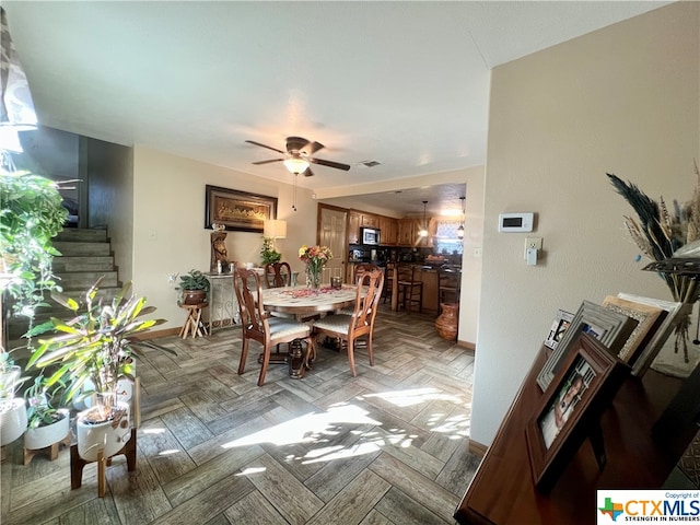 dining area featuring ceiling fan and light parquet floors