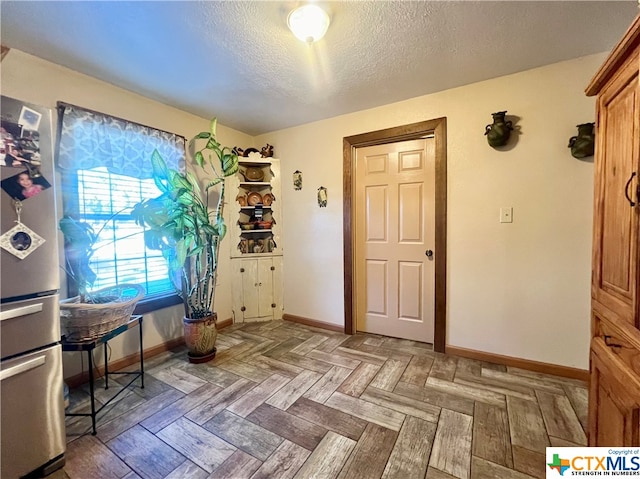 interior space featuring parquet flooring and a textured ceiling