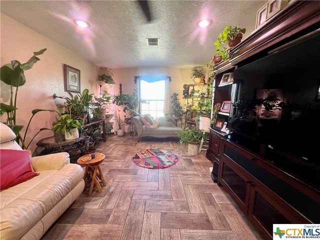 living room featuring a textured ceiling and light parquet floors