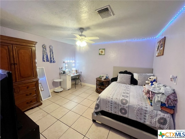 bedroom featuring a textured ceiling, ceiling fan, and light tile patterned floors