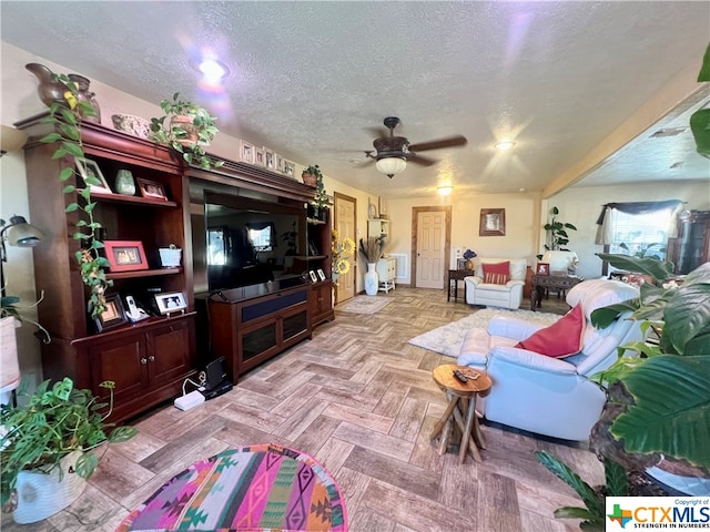 living room featuring a textured ceiling, ceiling fan, and light parquet floors