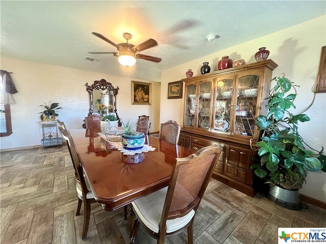 dining area with dark parquet floors and ceiling fan