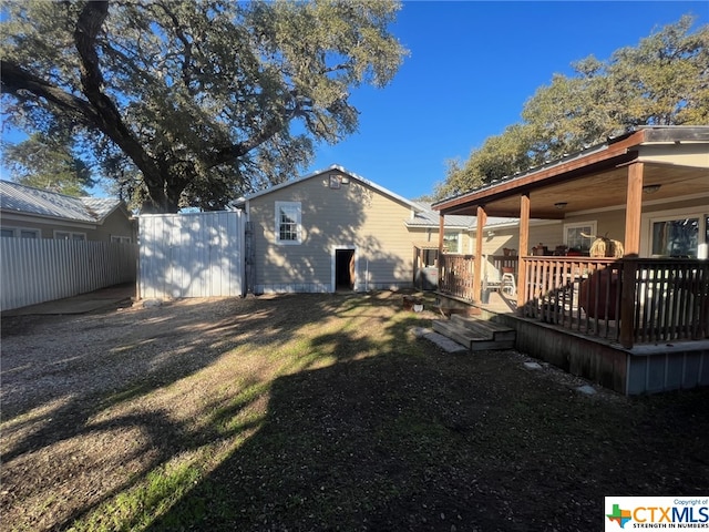 rear view of property featuring a lawn and a deck