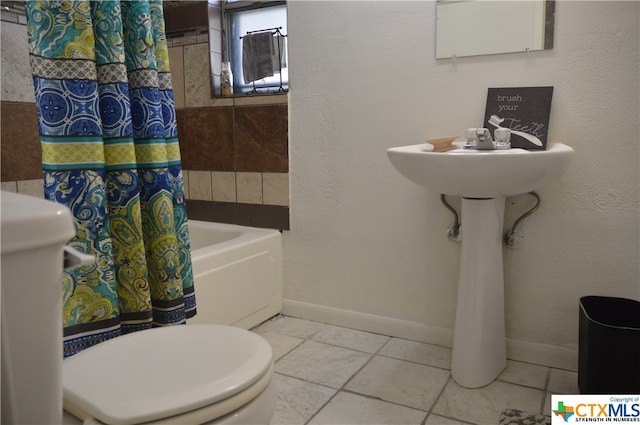 bathroom featuring toilet, shower / bath combo, and tile patterned floors