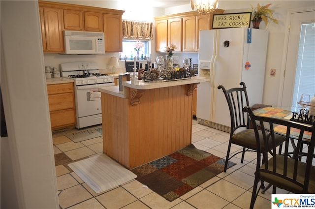 kitchen with a kitchen breakfast bar, white appliances, light tile patterned flooring, and a center island