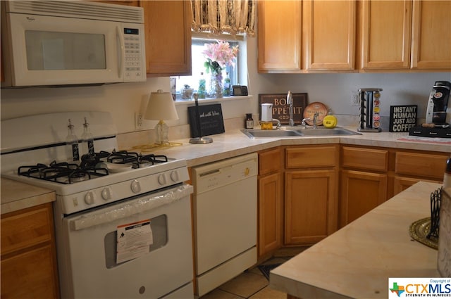 kitchen featuring white appliances, sink, and light tile patterned floors