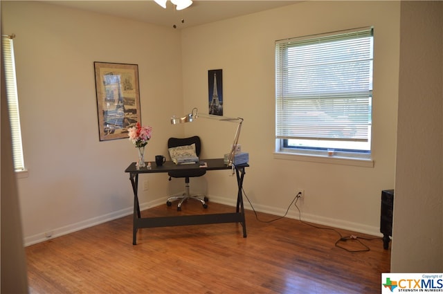 home office with ceiling fan, wood-type flooring, and a healthy amount of sunlight