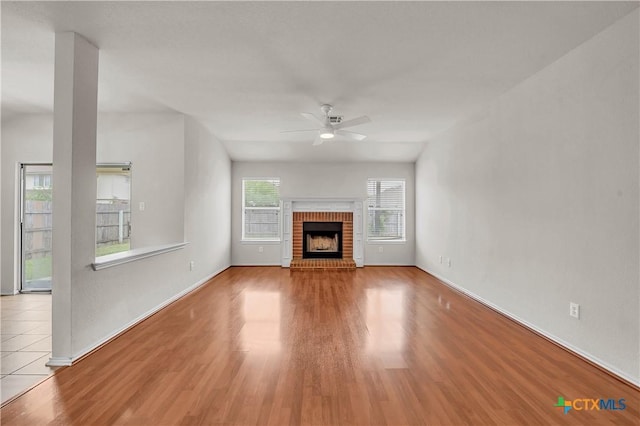3037 Rain Dance Loop, Harker Heights, TX 76548 - unfurnished living room featuring ceiling fan, wood finished floors, baseboards, and a brick fireplace