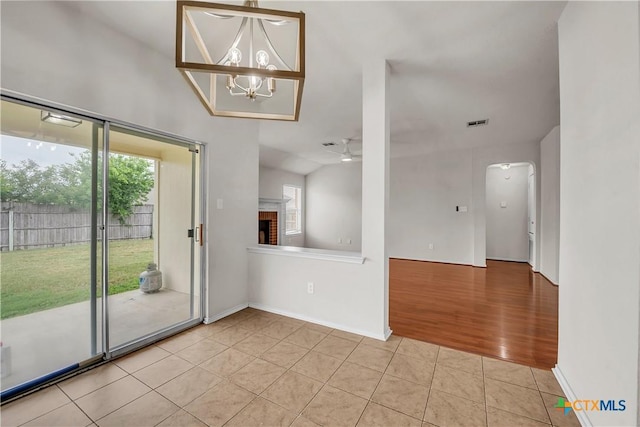 3037 Rain Dance Loop, Harker Heights, TX 76548 - empty room with healthy amount of natural light, light tile patterned floors, a fireplace, and a chandelier