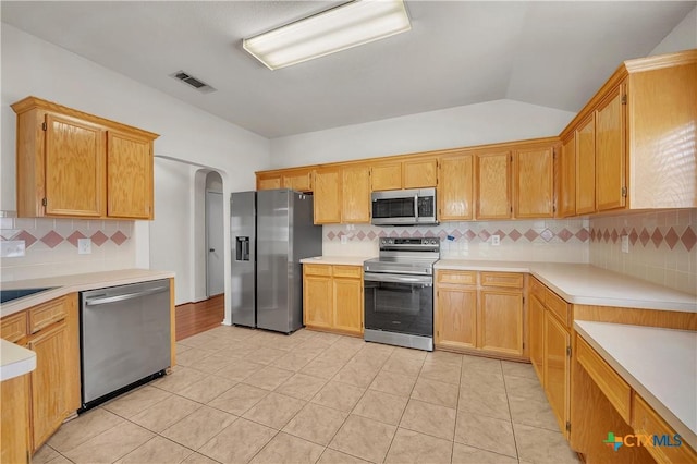 3037 Rain Dance Loop, Harker Heights, TX 76548 - kitchen featuring appliances with stainless steel finishes, decorative backsplash, arched walkways, light tile patterned flooring, and light countertops