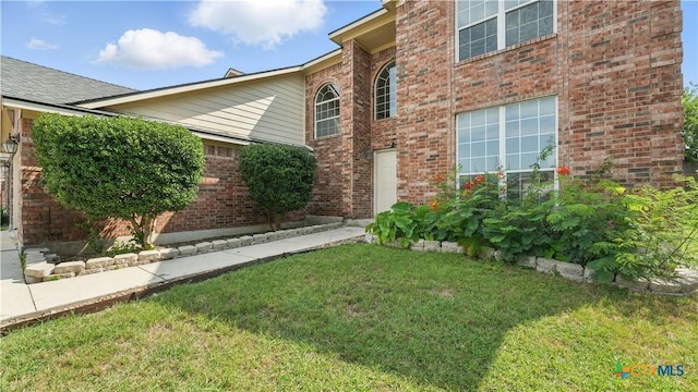 2166 Jolie Ct, New Braunfels, TX 78130 - view of exterior entry with a yard and brick siding