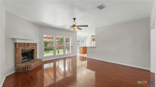 2166 Jolie Ct, New Braunfels, TX 78130 - unfurnished living room featuring a ceiling fan, wood finished floors, and a brick fireplace