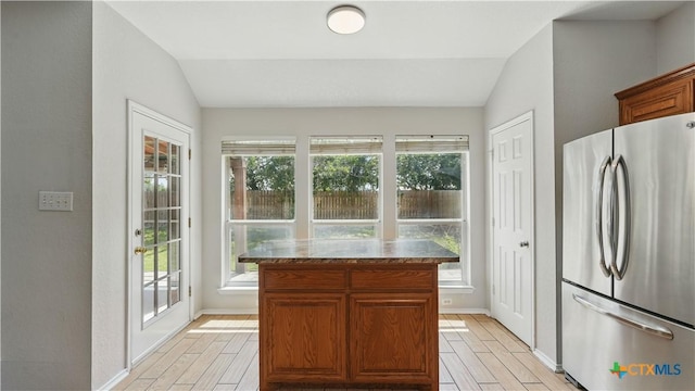 2166 Jolie Ct, New Braunfels, TX 78130 - kitchen featuring freestanding refrigerator, lofted ceiling, plenty of natural light, wood tiled floors, and a kitchen island